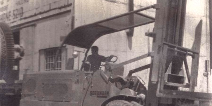 1940s B&W photo of operator driving large forklift