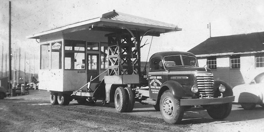 1940s B&W photo of transport truck trailer loaded with toll booth for bridge construction project